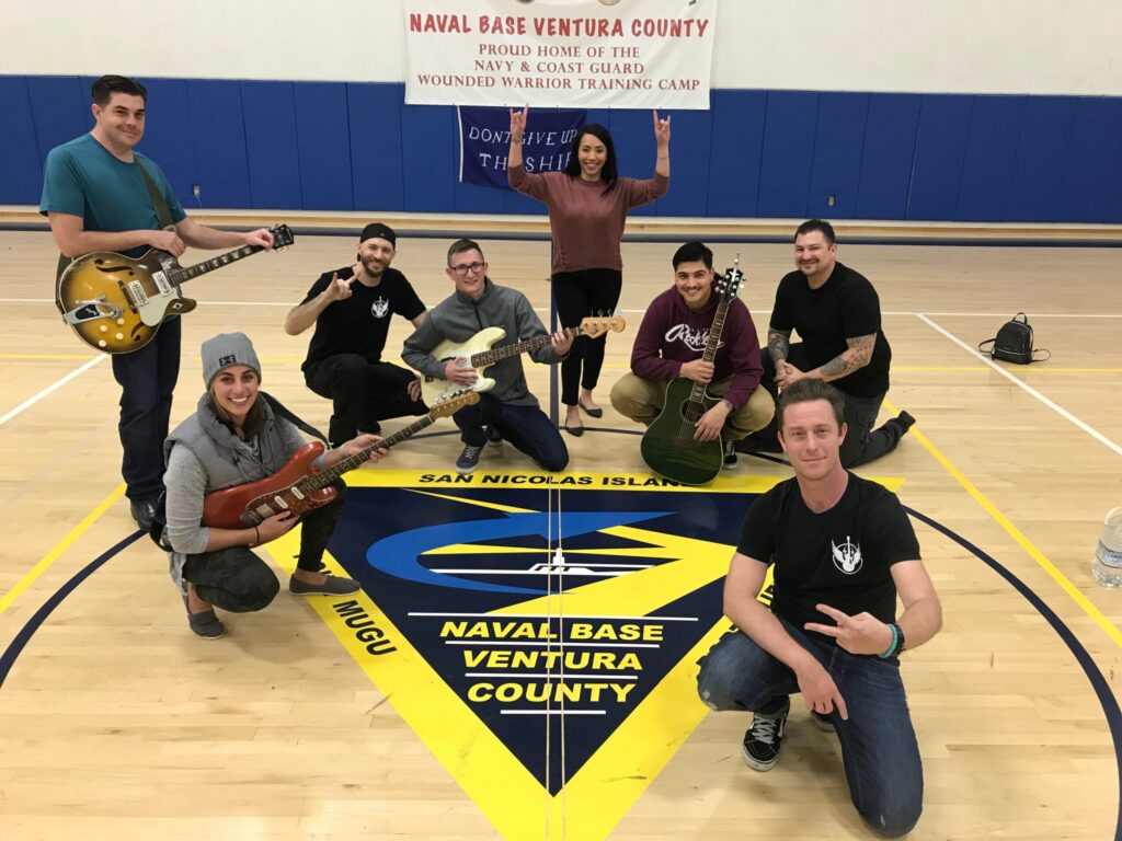 Rock to Recovery participants gathered in a circle playing instruments together